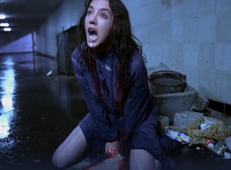 a woman sitting on the ground with blood dripping from her mouth